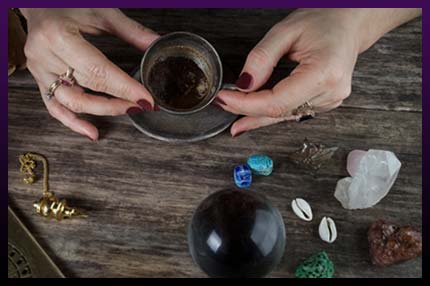 Witch casting magic ritual with gemstones